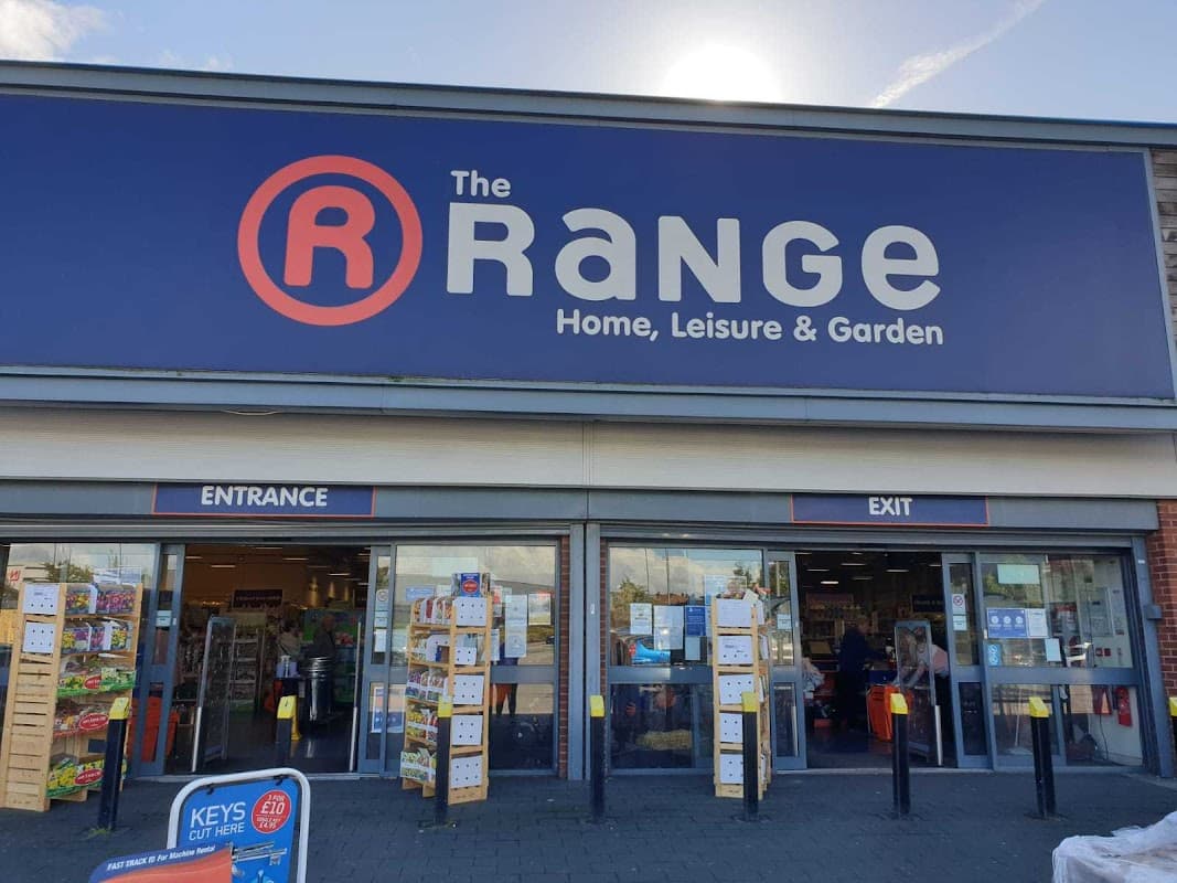 The Range store facade with large signage, entrance and exit doors, and displays of products outside.