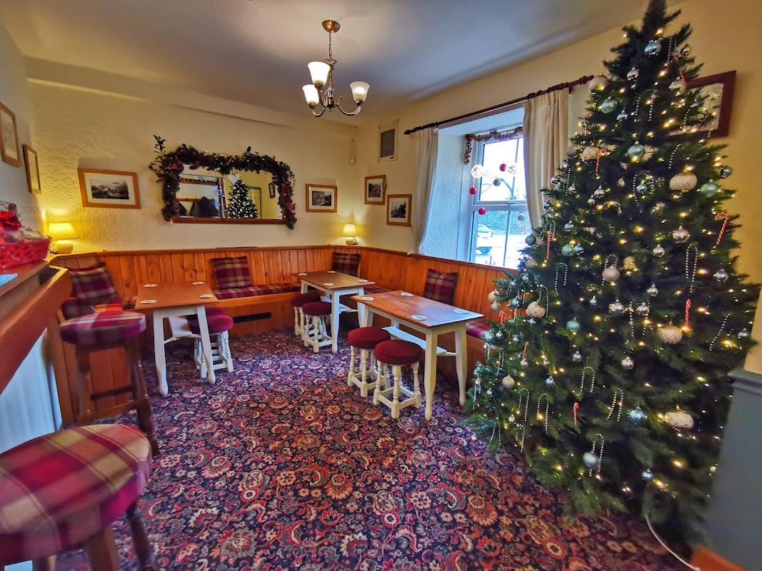 Cozy bar interior with festive Christmas tree, wooden furniture, and warm lighting in Embsay, Yorkshire.