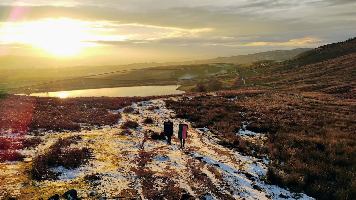 Sunrise over Embsay Nature Reserve, showcasing rolling hills, a tranquil pond, and a snowy path leading into the landscape.