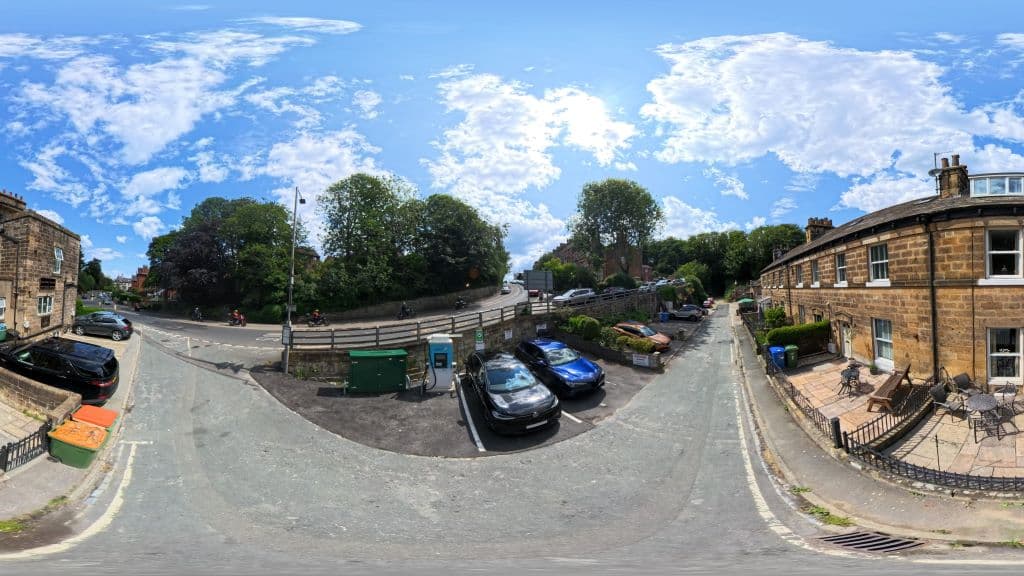 Zest Charging Station in Ewe Cote, Whitby, with cars parked and greenery under a bright blue sky.