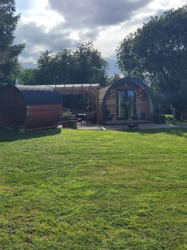 Cozy wooden pods with a patio, surrounded by greenery and trees at Four Wynds Bed and Breakfast in Faceby, Yorkshire.