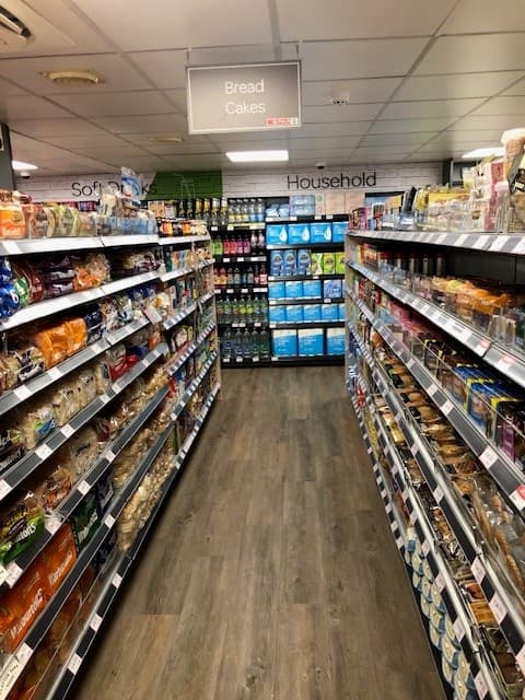 Aisle in SPAR grocery store with shelves of bread, cakes, and various household products in Gilberdyke, Yorkshire.