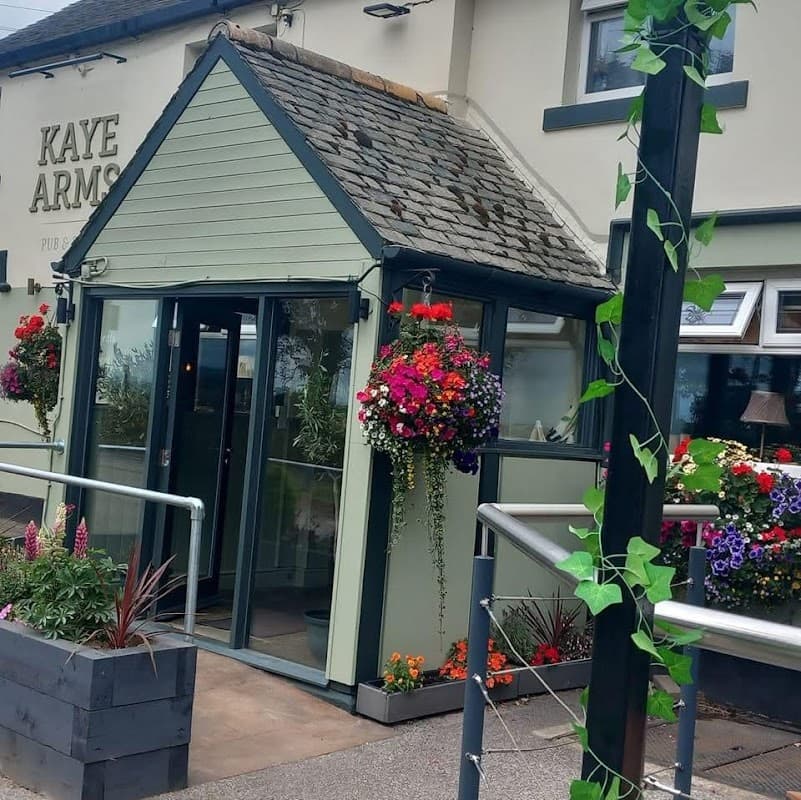 The Kaye Arms features a charming entrance with vibrant flower baskets and a cozy porch area.