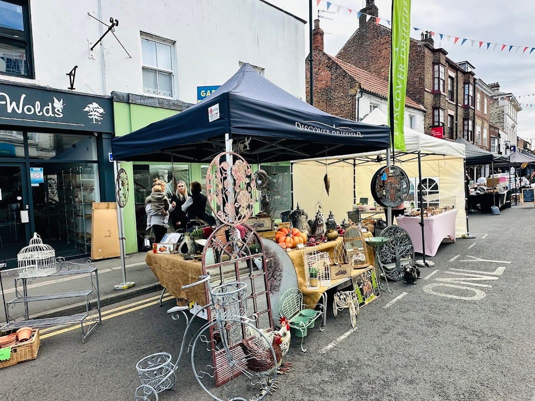 Stalls filled with goods, including decorative items and produce, line a street in Driffield Thursday Market.