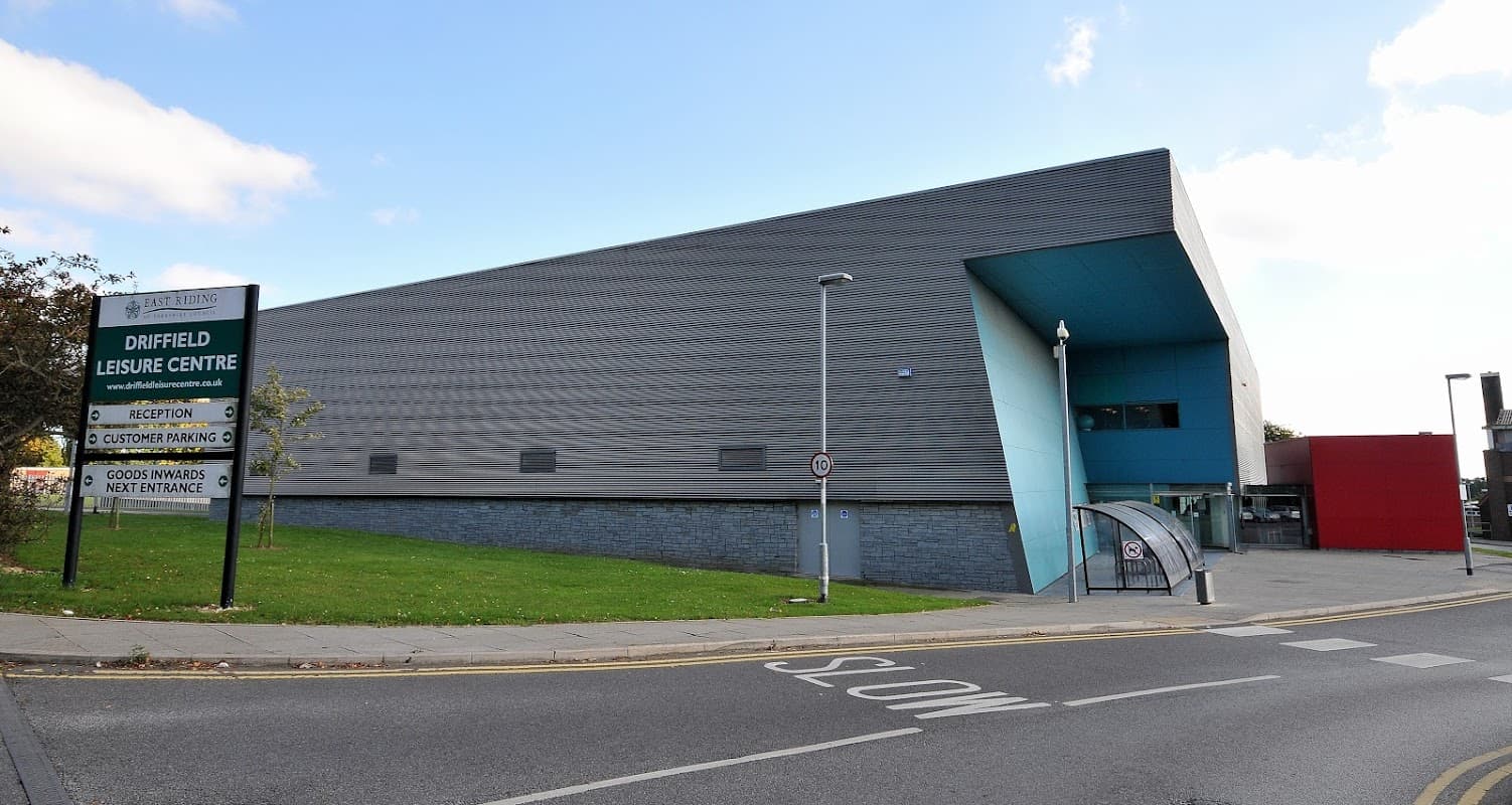 Modern leisure center with a sleek exterior, signage for Driffield Leisure Centre, and accessible entrance ramp.