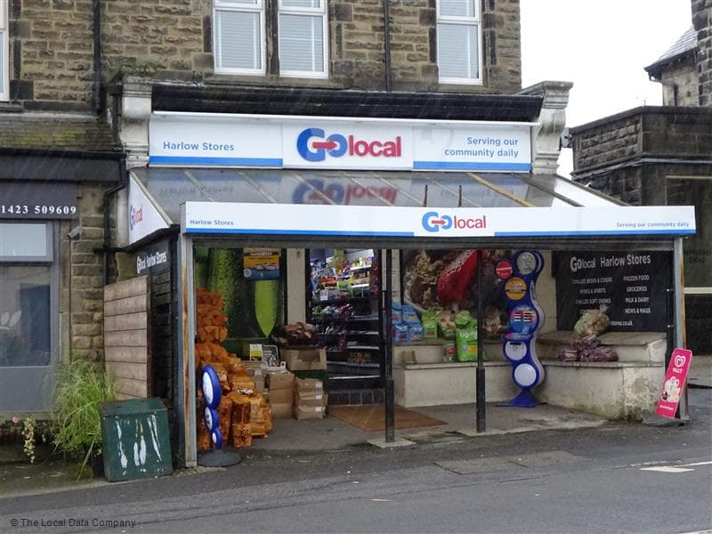 Harlow Stores with a colorful display of groceries, snacks, and drinks outside, located in a stone building in Harrogate.