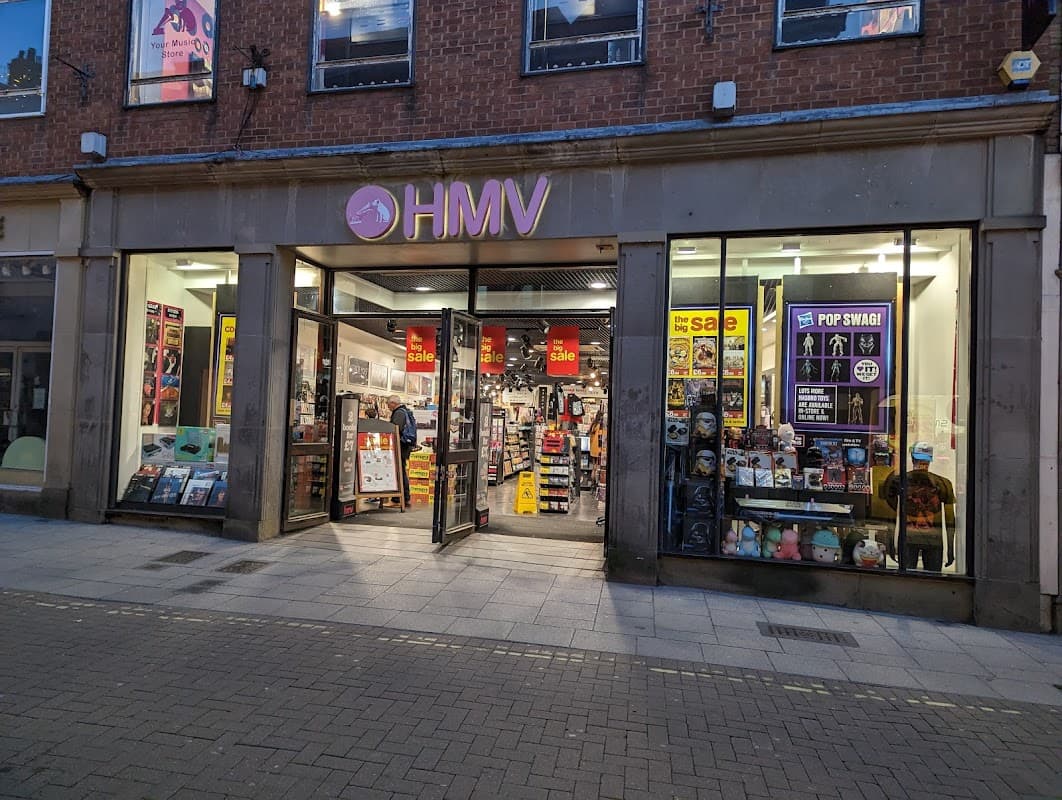 HMV store front in Harrogate, featuring colorful signage, sale posters, and a variety of music and merchandise displays.