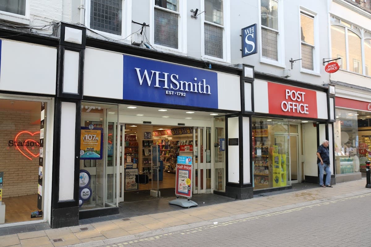 WHSmith store with blue signage and Post Office nearby, both located on a pedestrian street in Harrogate, Yorkshire.