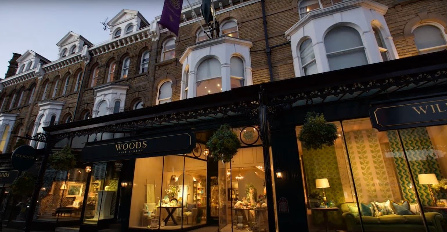 Elegant storefront of Woods Fine Linens with decorative windows, showcasing stylish home furnishings in Harrogate, Yorkshire.