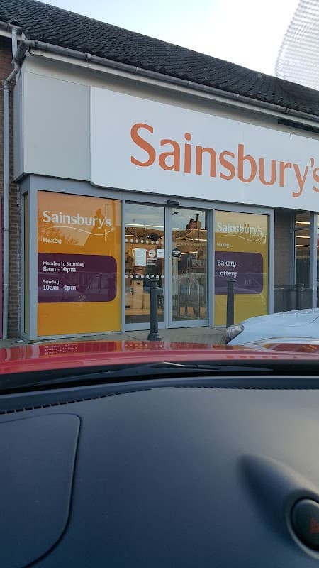 Sainsbury's store entrance in Haxby, Yorkshire, featuring signage for bakery and lottery services.