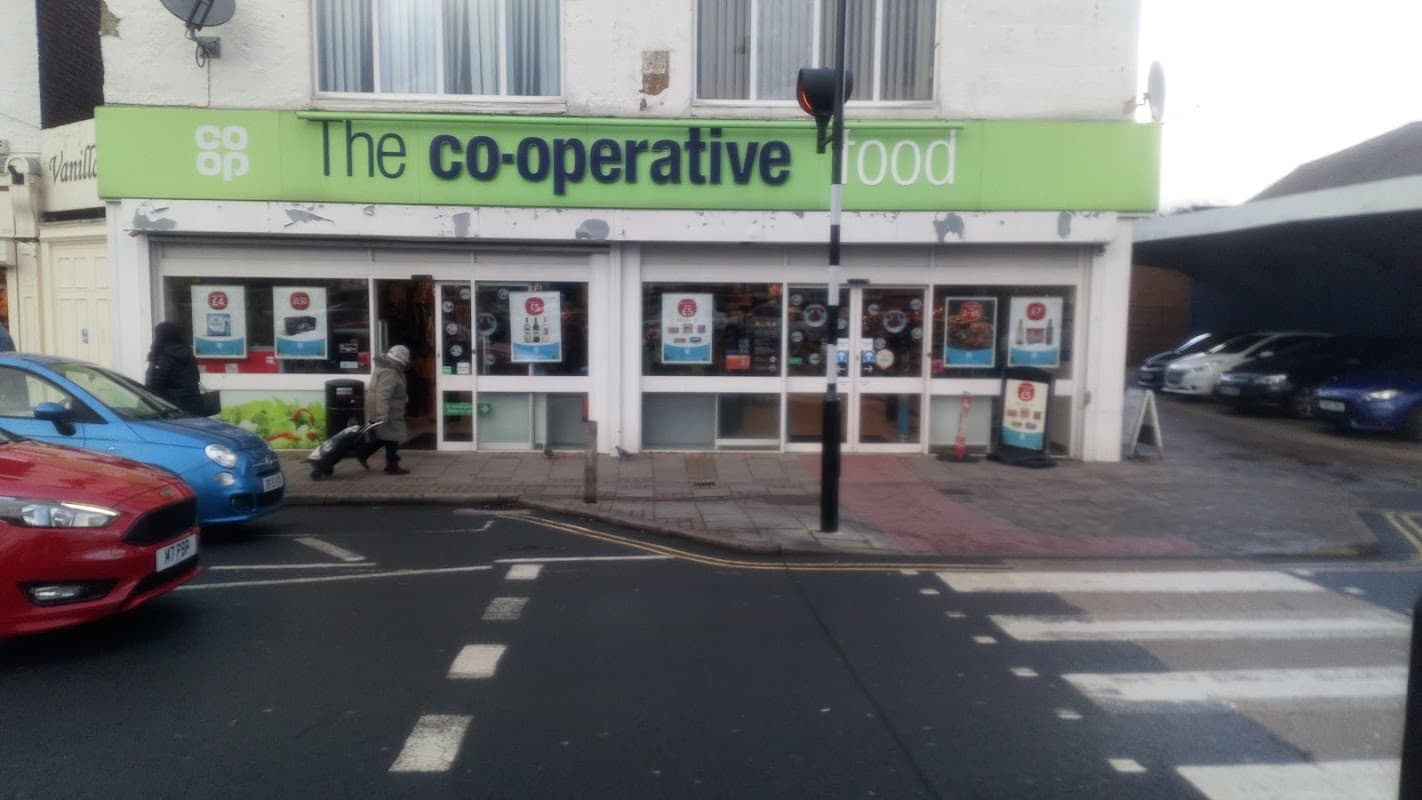 Co-op Food storefront in Hessle, featuring large windows with promotional signs and shoppers outside.