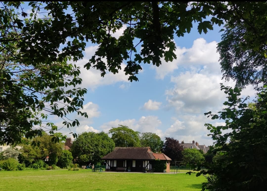 Glen Gardens building surrounded by lush greenery and trees under a partly cloudy sky in Heworth, Yorkshire.