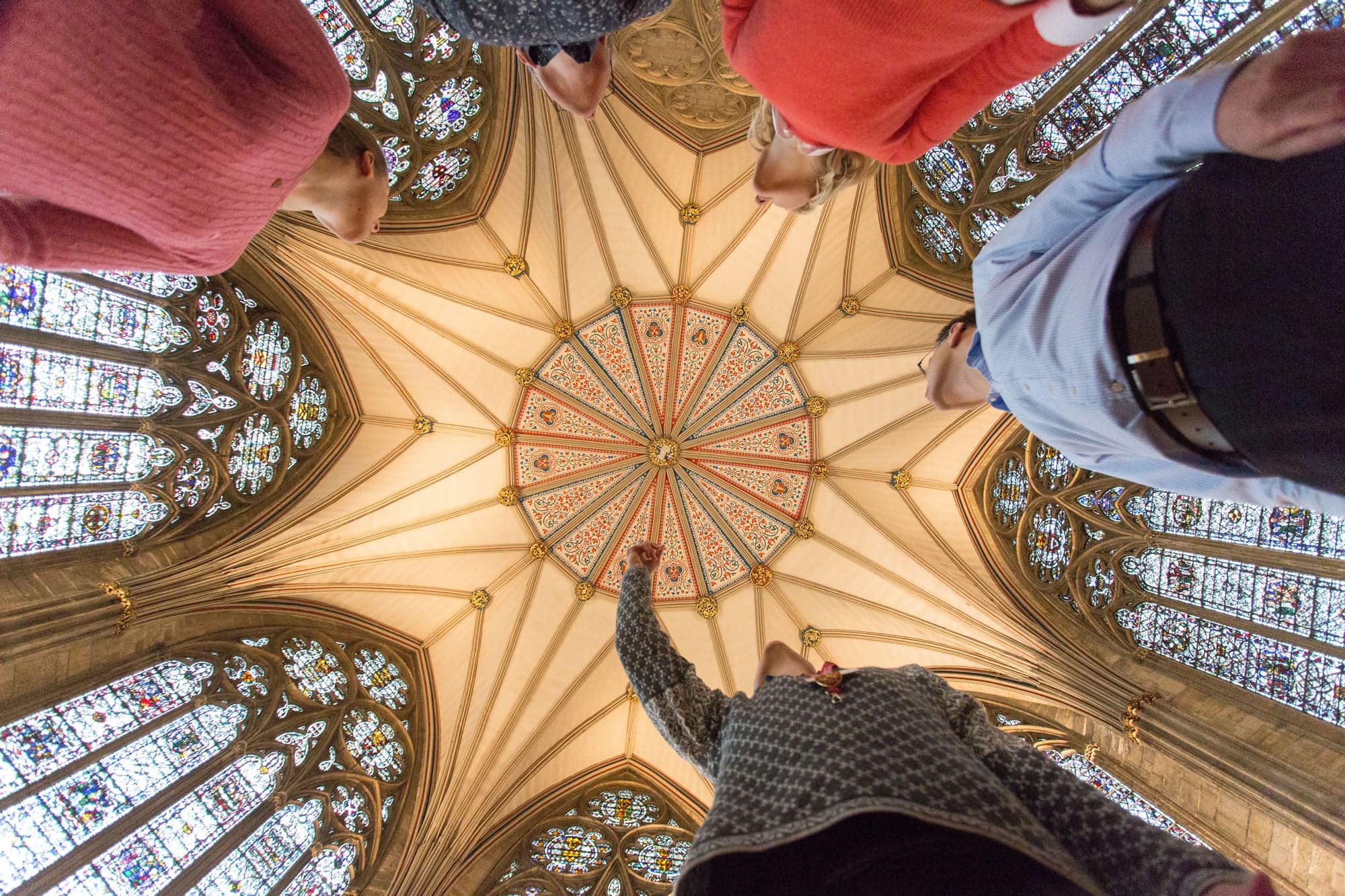 Visitors gaze up at York Minster's ornate, stained glass ceiling and intricate stonework.