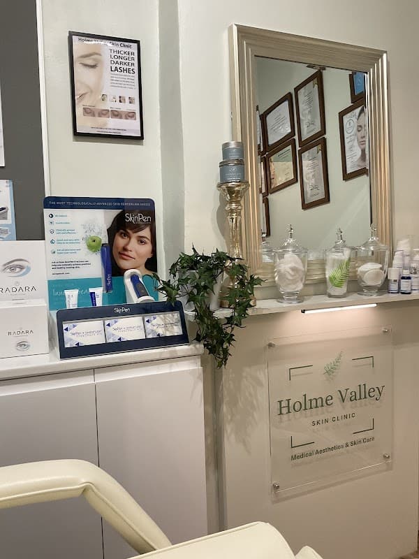 Reception area of Holme Valley Skin Clinic with a mirror, skincare products, and framed certificates on the wall.