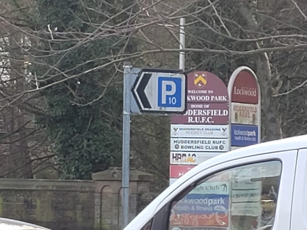 Signage indicating free parking at Water Street Car Park, with nearby club and park information in Huddersfield, Yorkshire.