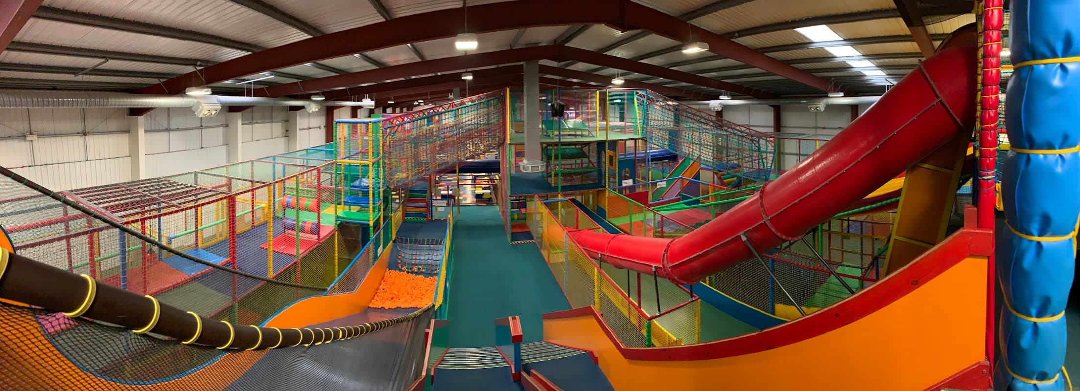 Colorful indoor play area with climbing structures, slides, and netted enclosures for children at Big Top - Hull.