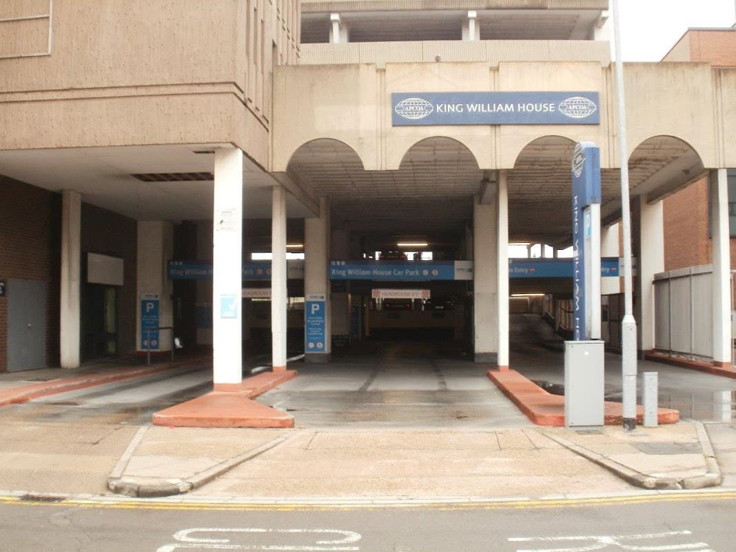 King William House car park entrance with marked parking spaces and signage in a concrete structure.