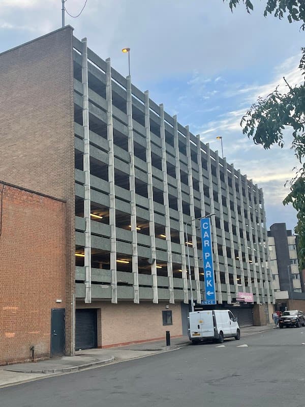 Multi-storey car park with concrete structure, blue "CAR PARK" sign, and a white van parked nearby in Hull, Yorkshire.