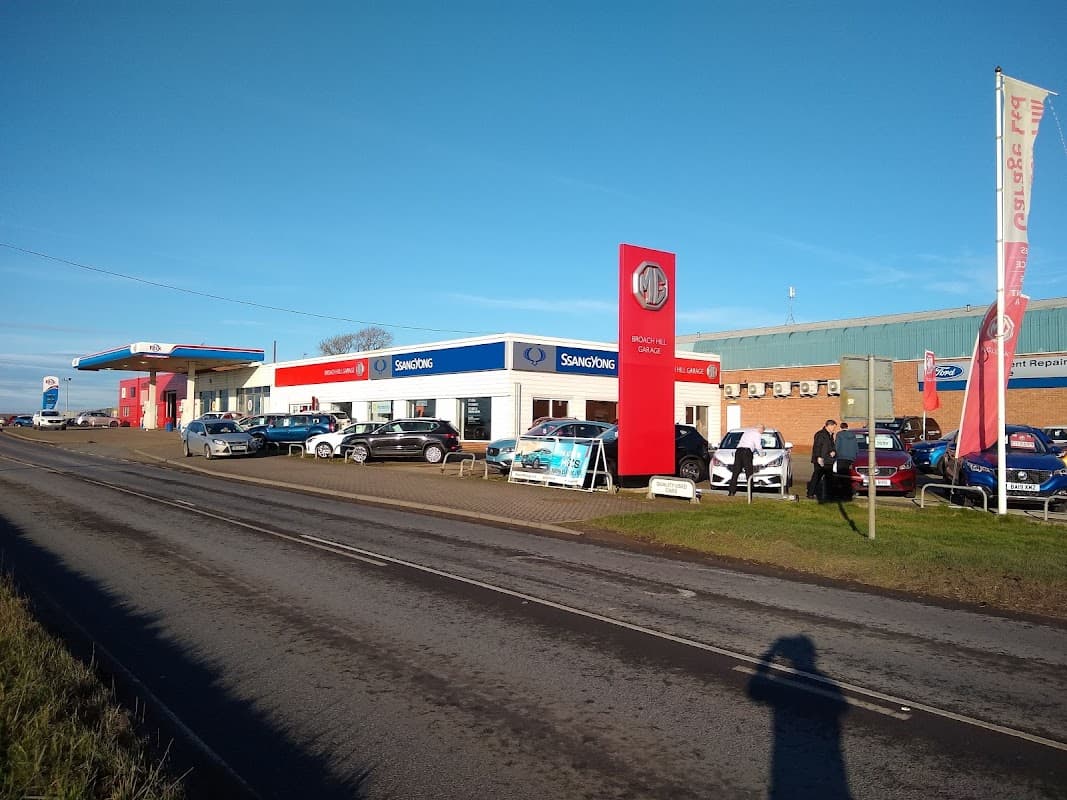 Livingstone Motor Group garage with cars displayed outside, blue sky, and signage for SsangYong and MG.