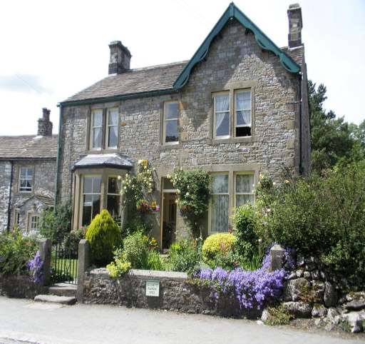 Charming stone guest house with flower-filled garden, surrounded by greenery in Kirkby Malham, Yorkshire Dales.