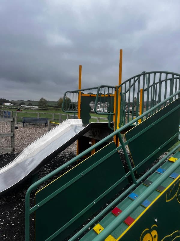 Playground equipment featuring a slide and climbing frame, set against a cloudy sky in Kirkheaton, Yorkshire.