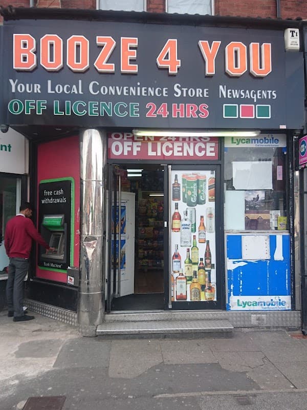 Signage for "BOOZE 4 YOU" with 24-hour off-license, featuring bottles displayed at the entrance and a newsagent section.