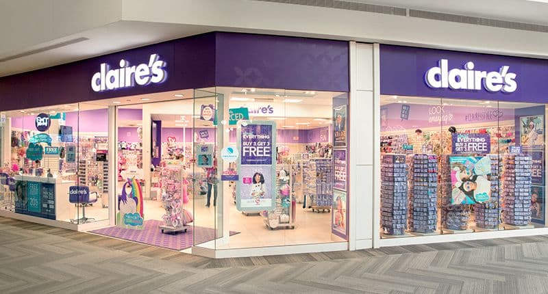 Storefront of Claire's, featuring vibrant purple signage and displays of jewelry and accessories.