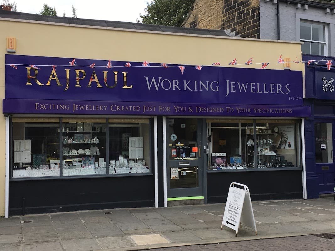 Storefront of Rajpaul Working Jewellers in Leeds, featuring a purple sign and various jewelry displays.
