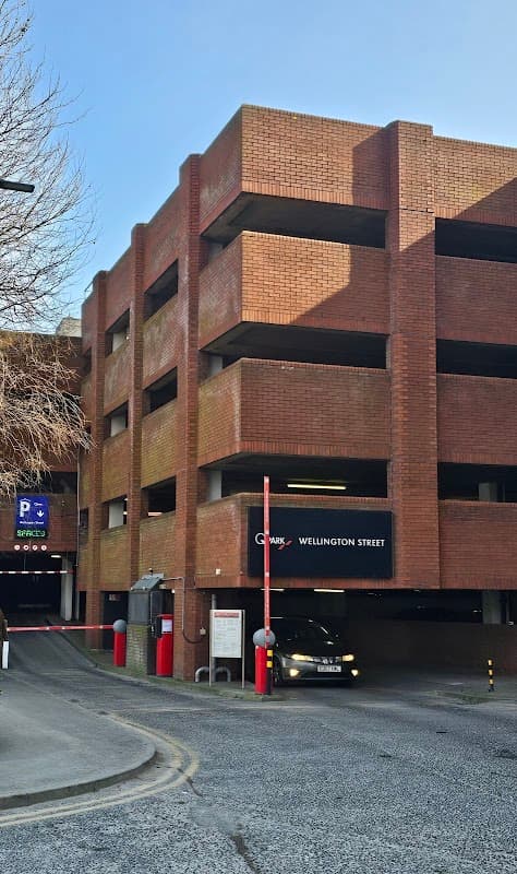 Wellington Street Multi Storey Car Park with red brick exterior and entrance, featuring a car and parking signage.