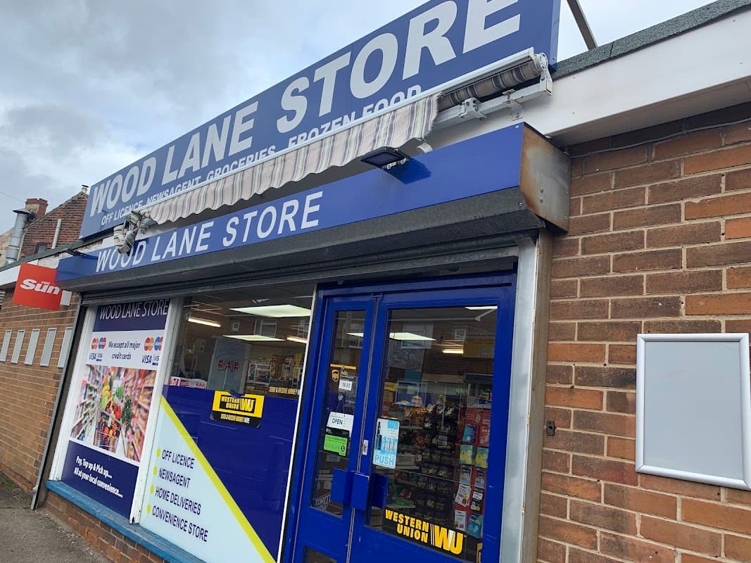 Wood Lane Store storefront featuring a blue sign, large windows displaying various products, and a brick exterior.