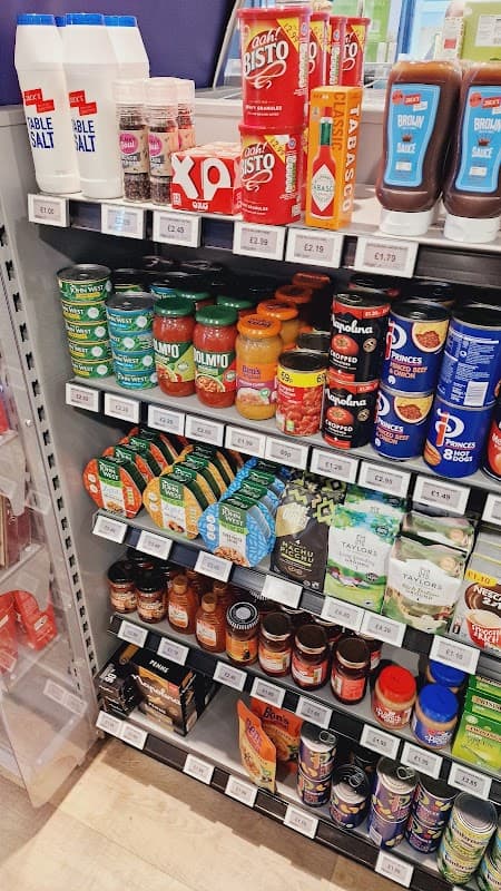Shelves stocked with various grocery items, including sauces, spices, and canned goods at Londis in Leeming Bar.