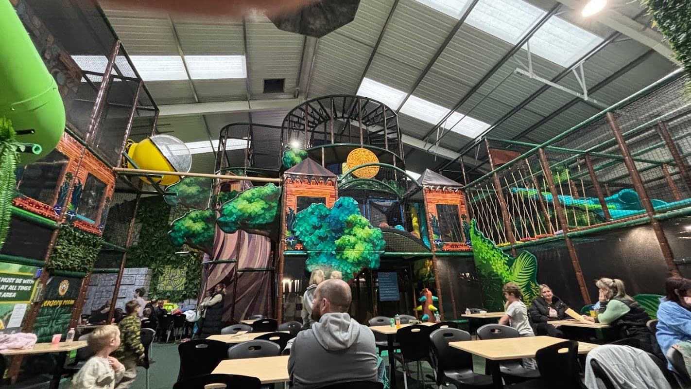 Indoor play area with colorful jungle-themed structures, slides, and seating for families in Leeming Bar, Yorkshire.