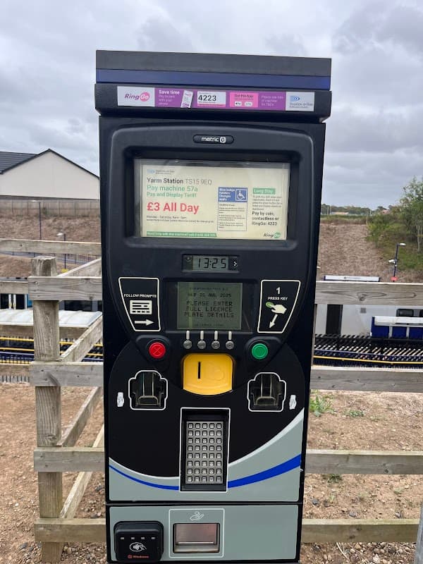 Parking meter at Yarm Station Car Park with payment options and instructions, surrounded by a wooden fence.