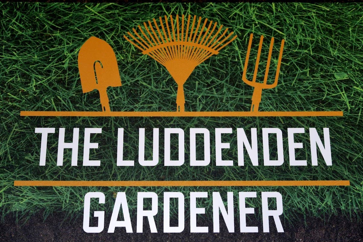Sign for "The Luddenden Gardener" featuring gardening tools on a green grass background.