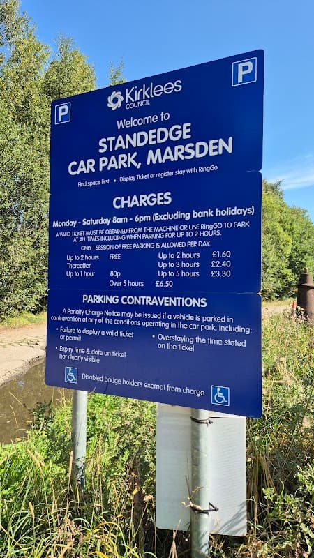 Welcome sign for Standedge Car Park with parking charges and regulations, surrounded by greenery in Marsden, Yorkshire.