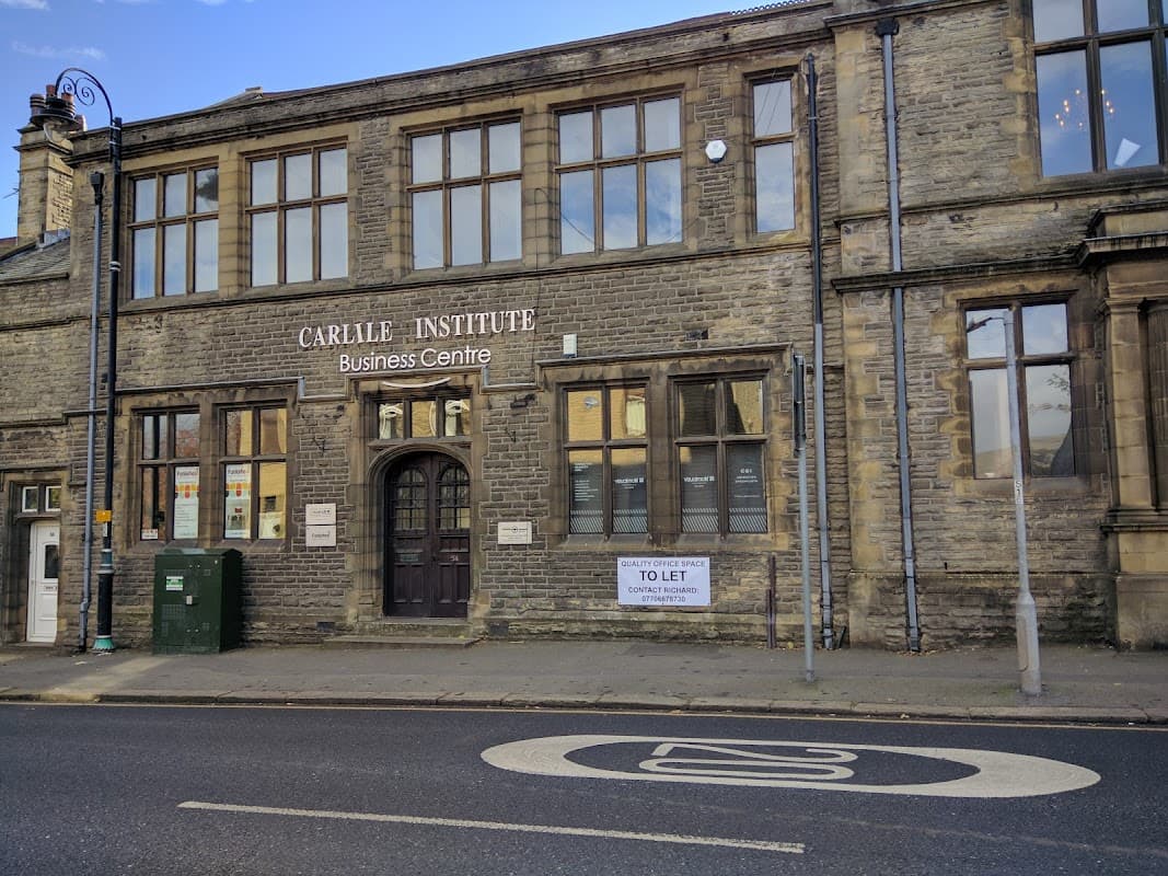 Historic stone building with large windows, featuring a sign for The Carlile Institute Business Centre and a "To Let" notice.