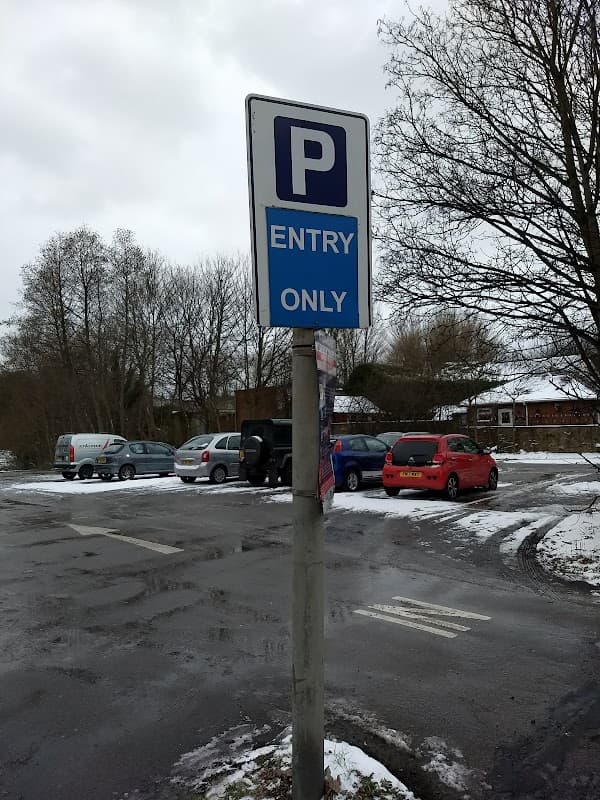 Pay & Display sign indicating "Entry Only" at Church Street Car Park, with parked vehicles and snowy surroundings.