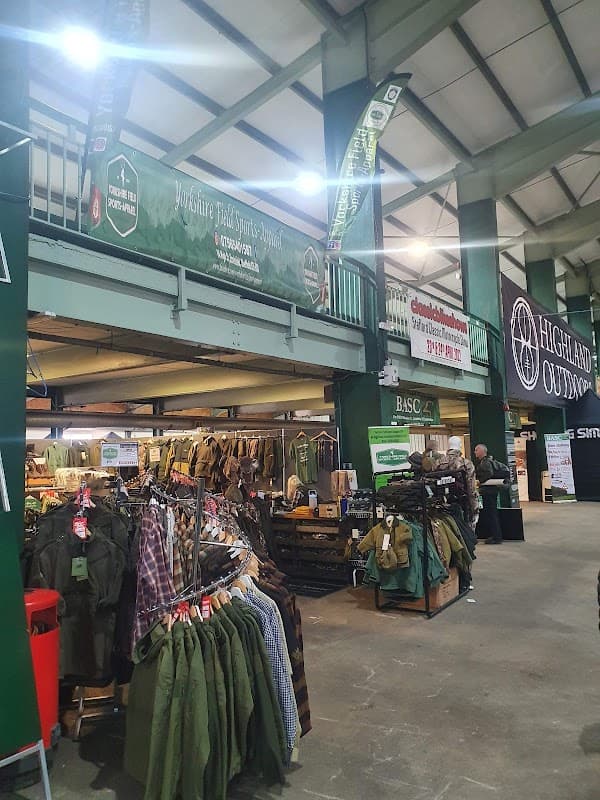 Shop interior featuring outdoor apparel, banners for Yorkshire Field Sports and Highland Outdoors, and racks of clothing.