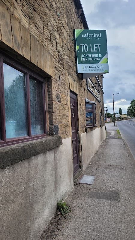 Stone exterior of The Old Bridge Inn with a "To Let" sign, located on a street in Monk Bretton, Yorkshire.