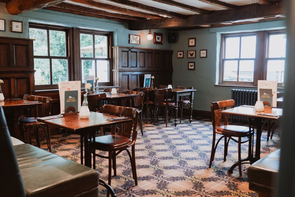 Cozy restaurant interior with wooden beams, patterned floor, and tables set for dining in Mosborough, Yorkshire.