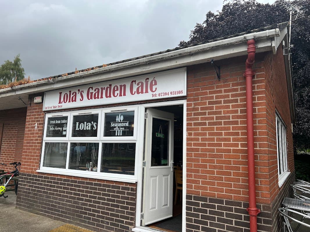 Lola's Garden Café with a brick exterior, large windows, and signage featuring the café's name and contact number.