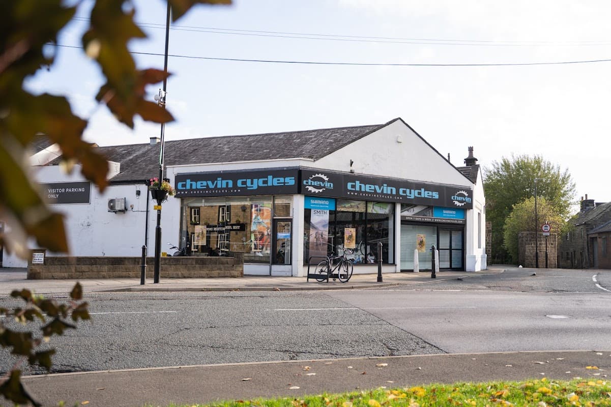 Chevin Cycles storefront in Otley, featuring large windows, signage, and a bicycle parked outside.
