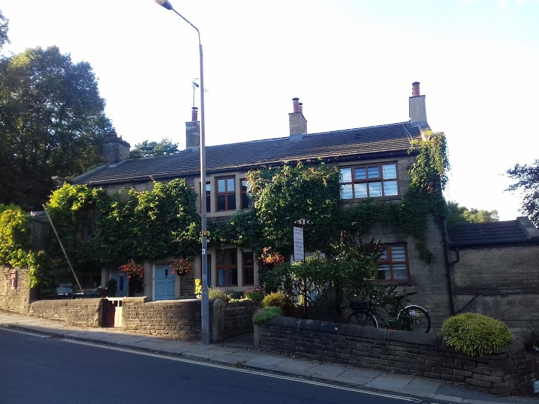 Charming stone cottage with ivy-covered walls, flower boxes, and a bicycle outside, set in a tranquil Yorkshire village.