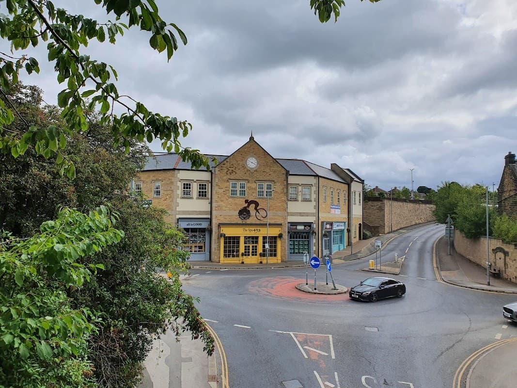The Spa 493 building with a clock, surrounded by trees, near a roundabout in Penistone, Yorkshire.
