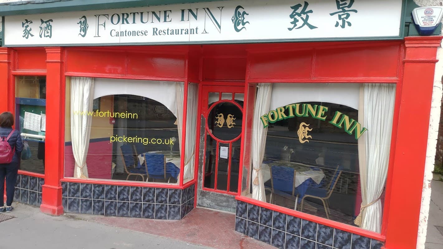 Bright red exterior of Fortune Inn, a Cantonese restaurant, featuring large windows and a welcoming entrance.
