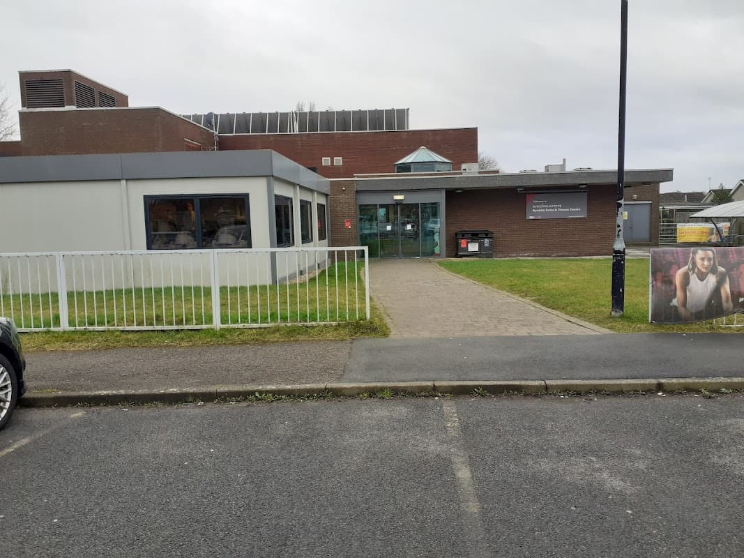 Modern building with large windows, green grass, and a pathway leading to the entrance of Ryedale Swim and Fitness Centre.