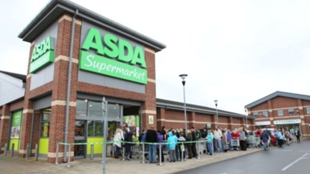 Asda Supermarket entrance with a long queue of shoppers outside, cloudy sky above, in Redcar, Yorkshire.