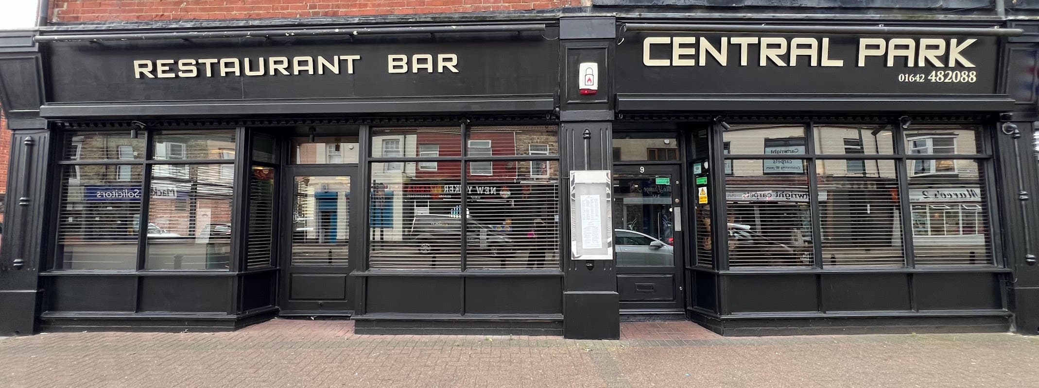 Black storefront with large windows, featuring "CENTRAL PARK" and "RESTAURANT BAR" signage.