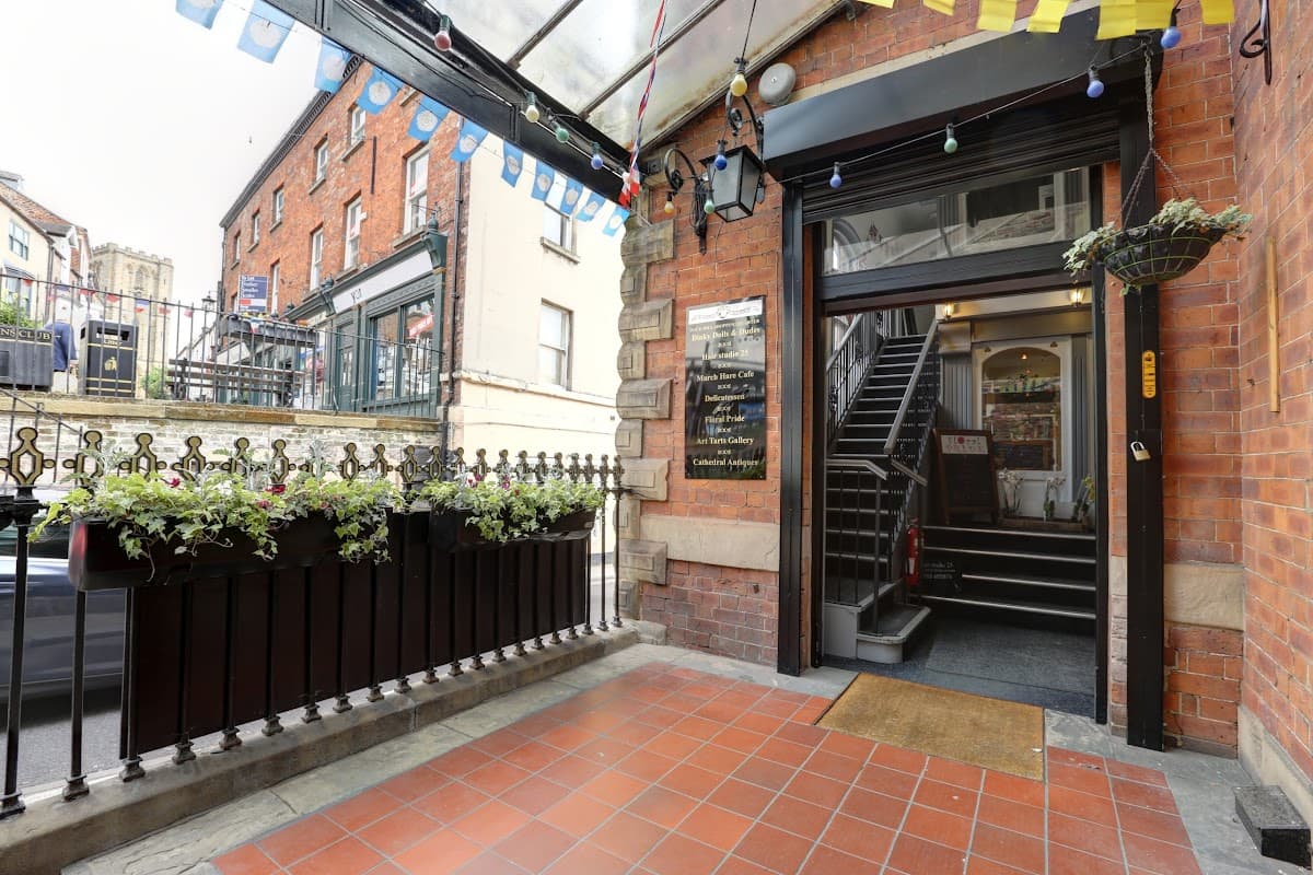 Entrance to Duck Hill Shopping Quarter with brick buildings, potted plants, and colorful bunting overhead.