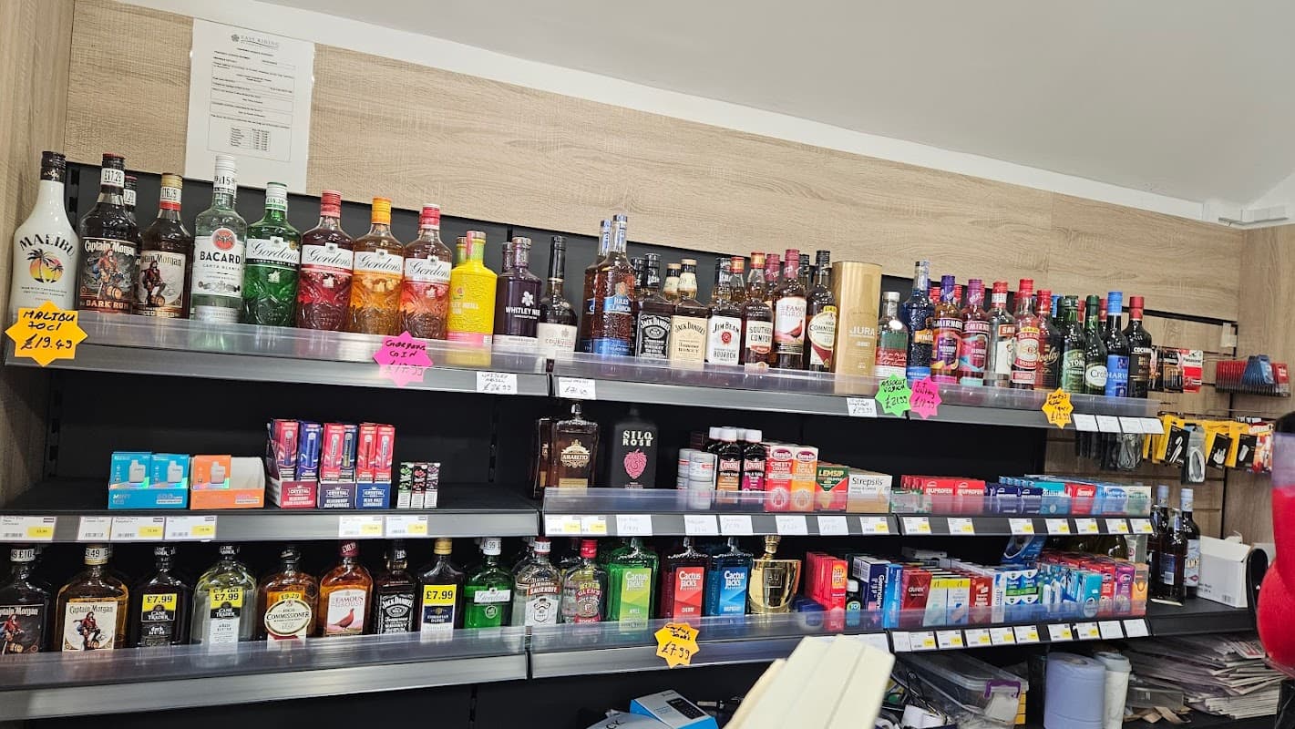 Shelves filled with various alcoholic beverages, mixers, and snacks, featuring colorful labels and price tags.